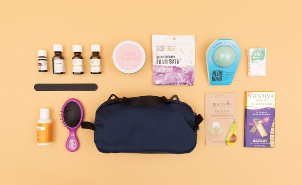 A Navy Parapack Grab Bag with various travel toiletry items next to it.